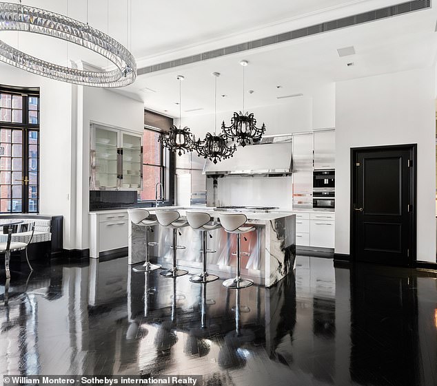 Three black chandeliers hang over the breakfast bar area in the kitchen.