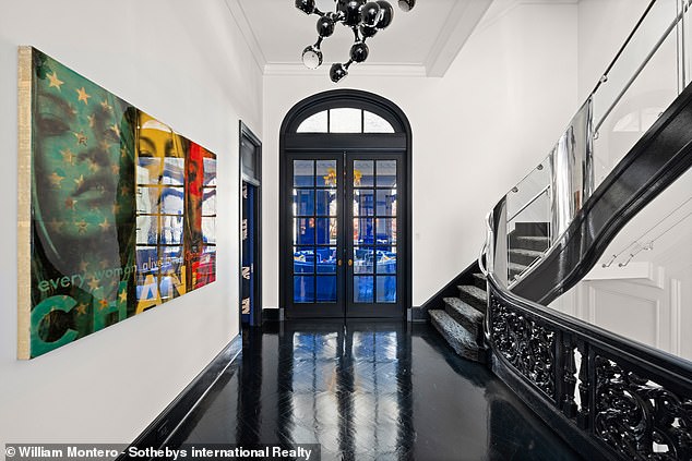 The hallway has black floors and carved wooden railings.