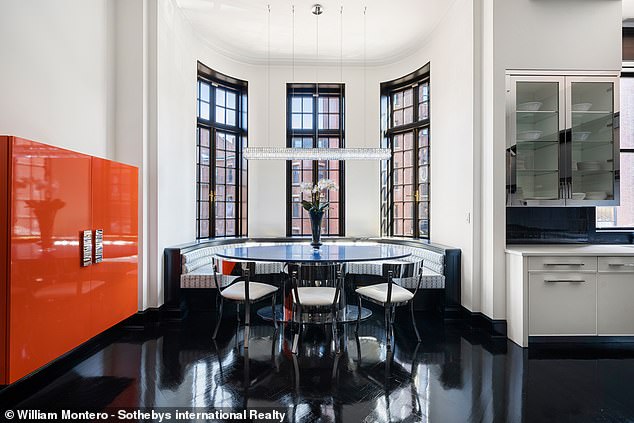 Natural light floods this dining room in the elegant black and white themed kitchen.