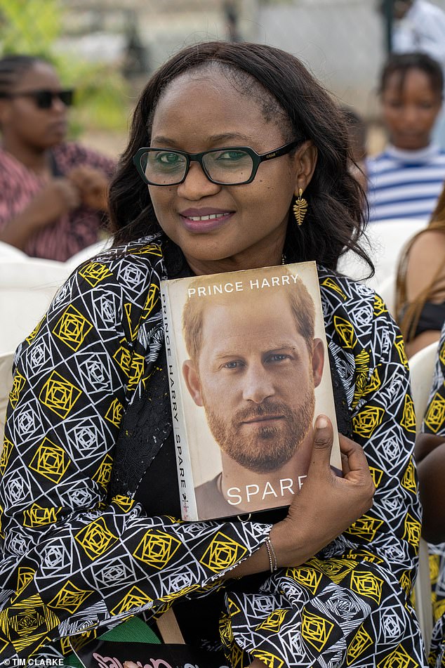 A fan holds a copy of Harry's memoirs; Maybe she was lucky enough to have the Prince himself sign it.