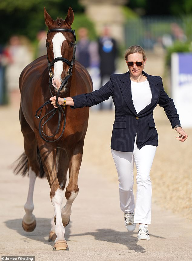 Looking effortlessly chic, equestrian Zara, 42, wore a striped jacket and white trousers paired with a matching blouse as she led her horse.