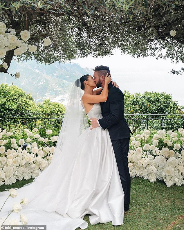 The couple shared a kiss under the stunning rose arch as they tied the knot, six months after getting engaged.