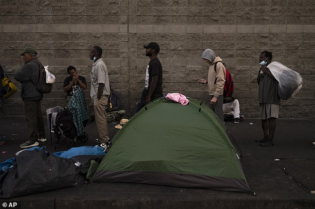 Homeless people line up for dinner outside the Midnight Mission in the Skid Row area of ​​Los Angeles.