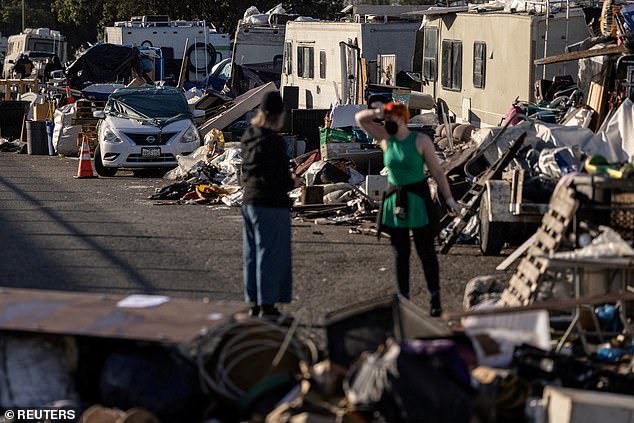 Volunteers help clean out belongings at a homeless encampment near the Nimitz Highway in Oakland after the city ordered a cleanup.