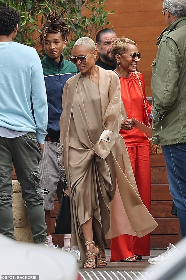 His wife Jada Pinkett Smith opted for a brown look, wearing a silky off-the-shoulder dress and a matching coat.