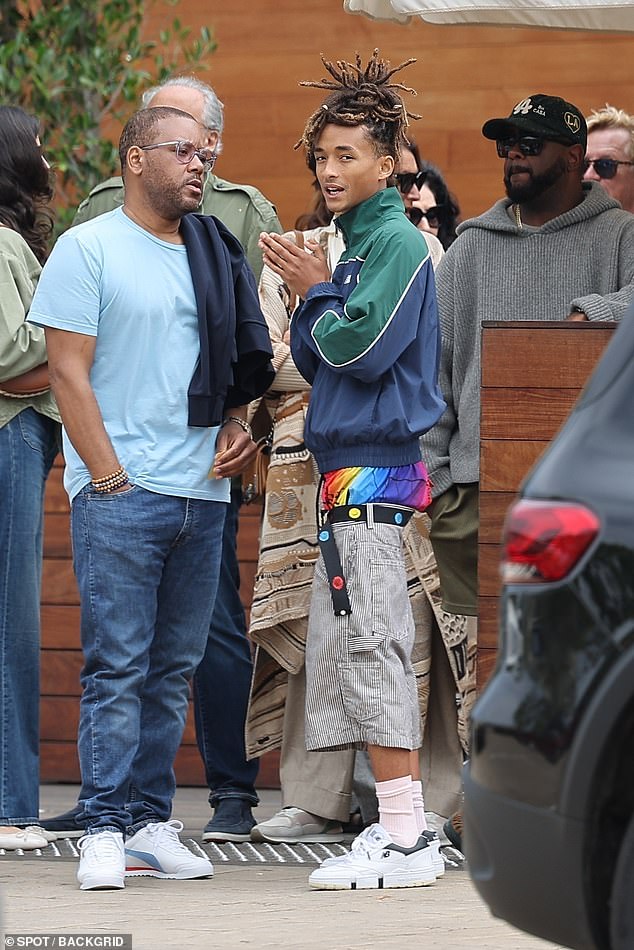 Jaden was dressed in a green and blue New Balance sports jacket with black and white striped shorts hanging down to reveal colorful boxers and white New Balance shoes.