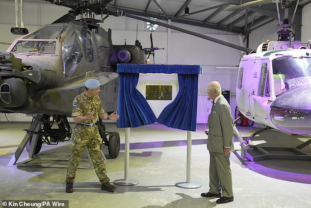 King Charles III unveils a plaque today during a visit to the Army Aviation Center in Middle Wallop