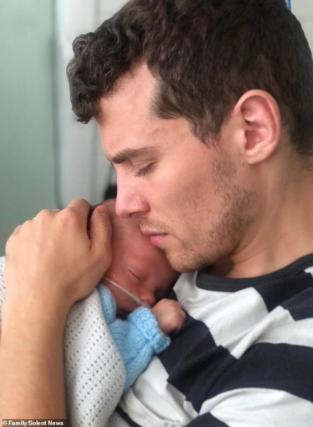 Father Jonny Davis held his son Orlando, who suffered an irreversible brain injury when his mother Robyn suffered a seizure, having developed hyponatremia during childbirth.