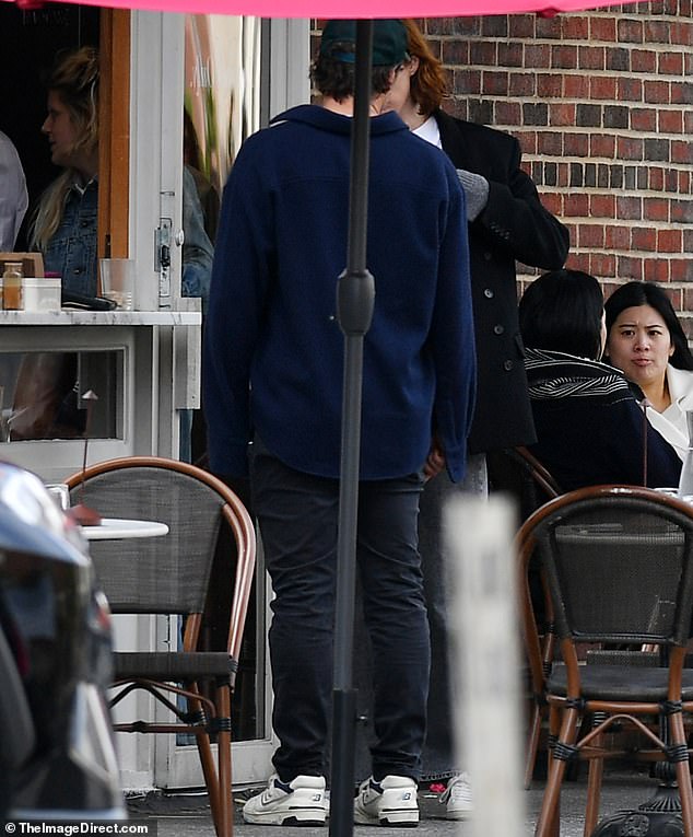 He had his back to the camera as she appeared to pay for his coffees.