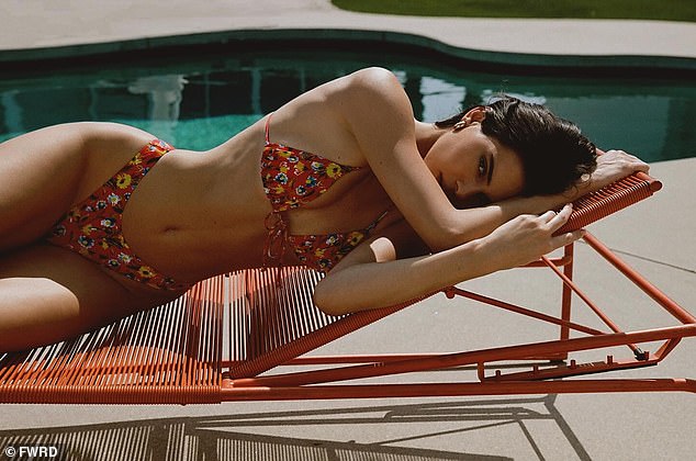 Kendall curled up on a couch in a floral-print bikini