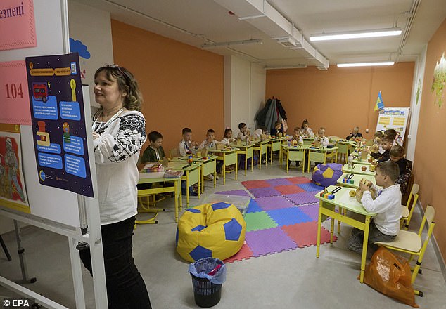 A teacher continues teaching her students in her classroom bunker despite Putin's latest attack taking place above them.