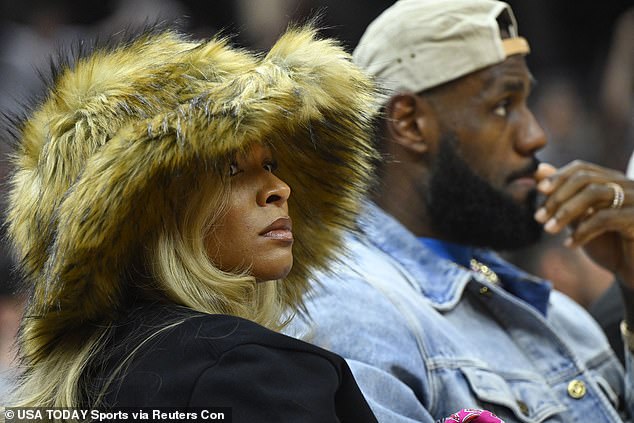 Savannah James, LeBron's high school girlfriend, stood out in a faux fur hat on the court.