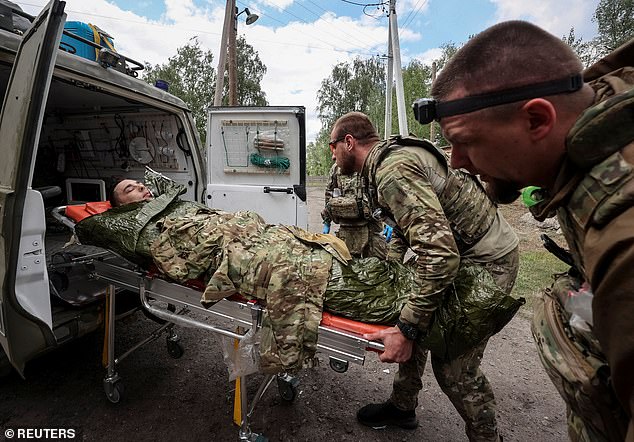 Paramedics treat a wounded Ukrainian service member, amid Russia's attack on Ukraine, near the town of Vovchansk in the Kharkiv region, Ukraine, yesterday.