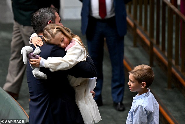 Australian Treasurer Jim Chalmers receives a hug from his daughter Annabel after delivering the 2024/25 budget statement as his son Leo looks on