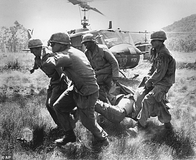 The body of a slain comrade is carried to an evacuation helicopter by soldiers of the US 1st Cavalry Division in the Ia Drang Valley early in the week of November 15, 1965.