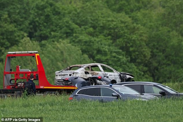 French authorities are seen towing a burned-out vehicle believed to have been used in the inmate's escape.