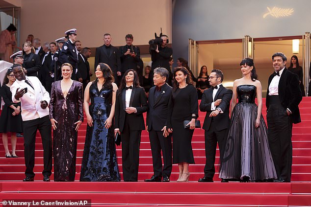 Jury president Greta Gerwig, second left, poses with jury members Omar Sy, from left, Lily Gladstone, Nadine Labaki, Kore-eda Hirokazu, Ebru Ceylan, JA Bayona, Eva Green and Pierfrancesco Favino.