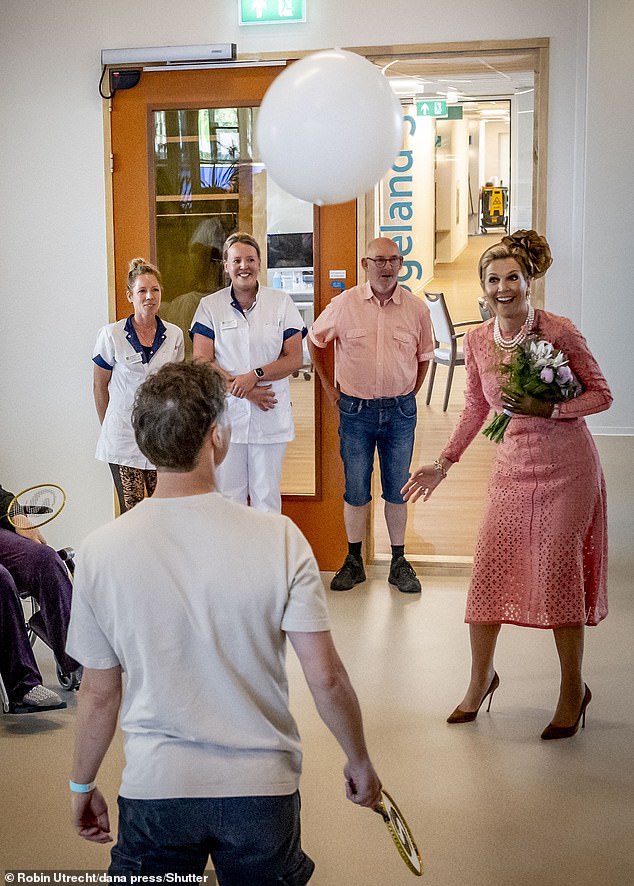 Máxima seems in high spirits as she appears to join in a game with some of the healthcare residents.