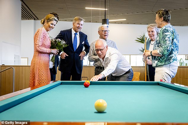 Queen Máxima and King Willem-Alexander watch as residents play pool