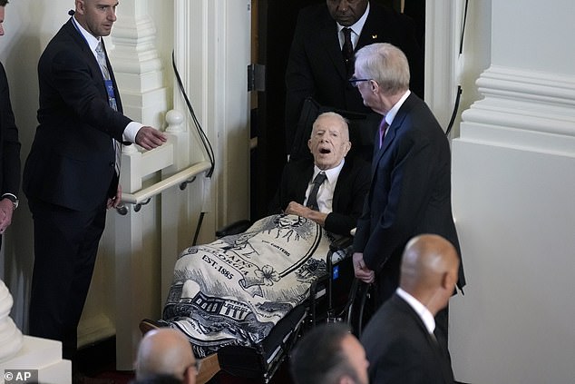 In November, he made a rare public appearance for his wife Rosalynn's funeral, in a wheelchair and covered in a blanket representing her face.