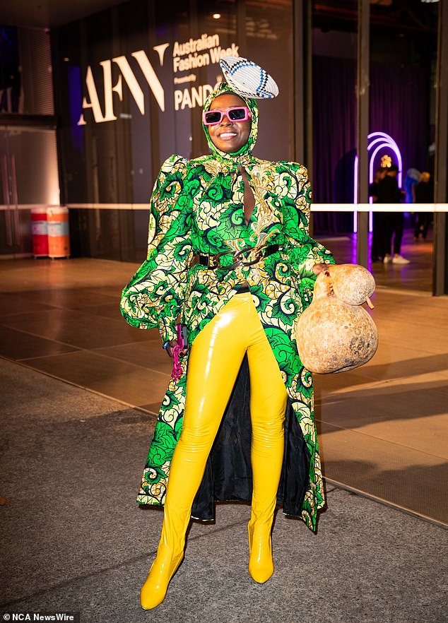 She also wore a green printed dress, yellow plastic boots, neon pink sunglasses and an African basket worn as a hat.