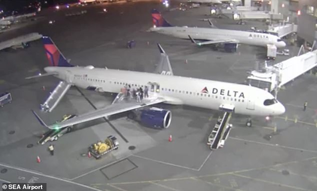 Passengers of the Airbus A321neo are seen evacuating. They climb onto the right wing of the plane, before sliding down the emergency slide just behind.