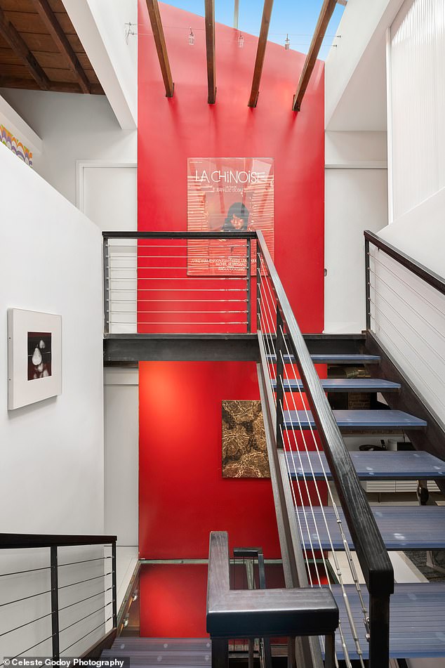 An eight-foot-wide panel of lipstick red rises 40 feet toward the skylight, as if shooting through the glass landings.