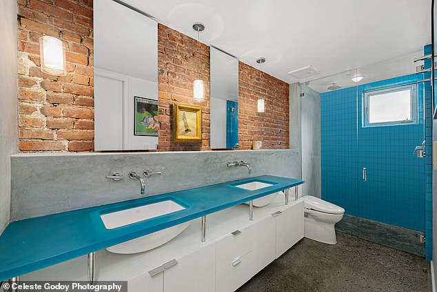 One of the bathrooms is covered with blue resin above the sinks and in the shower.