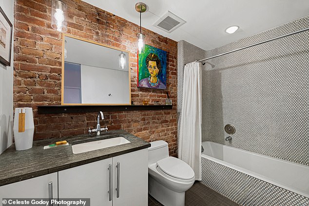 One of the bathrooms has a full bathtub and brownstone wall.