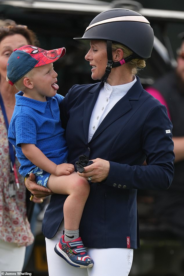 Lucas Tindall (pictured left) looked adorably mischievous as he stuck out his tongue while watching his mother, Zara Tindall, on day four of the Badminton Horse Trials.