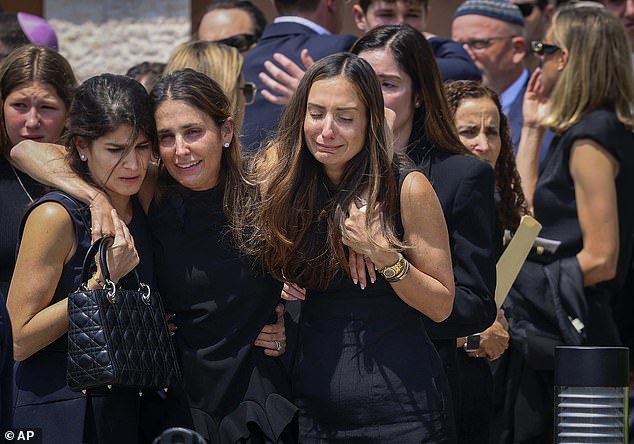 Mourners support each other as they leave Temple Beth Sholom after Adler's funeral in Miami on Monday.