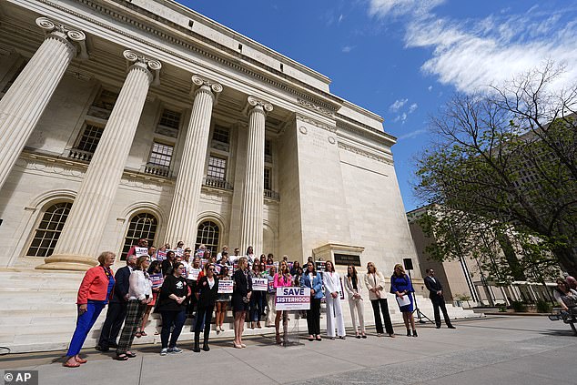 Riley Gaines, front center, an advocate for women's sports and privacy issues, speaks during a news conference outside the U.S. Court of Appeals for the 10th Circuit on Tuesday, May 14, 2024, in Denver.