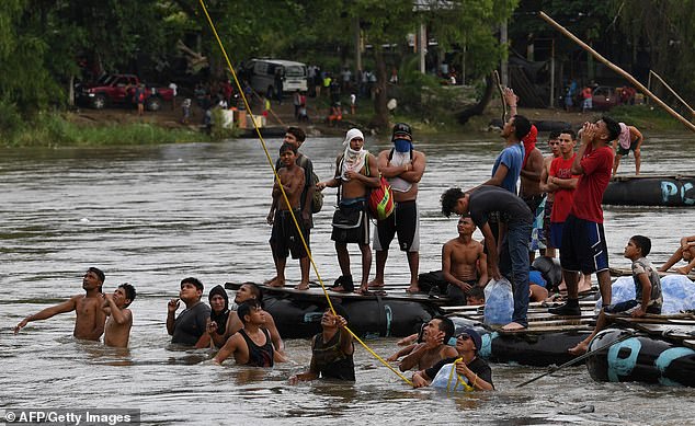 New York City's leader said the shortfall could be resolved if work permits for immigrants could be expedited. In the photo: Honduran migrants heading to the United States wait for other migrants to jump from the international border bridge between Guatemala and Mexico into the Suchiate River in 2018.