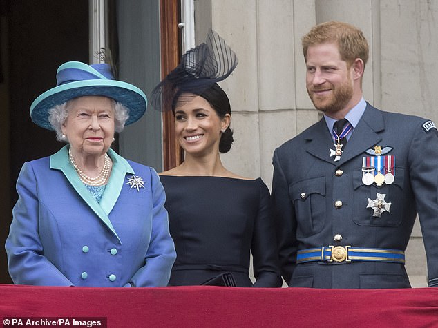 Queen Elizabeth II smiles with Harry and Meghan on the balcony of Buckingham Palace in 2018