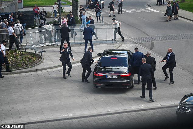 Security officers put Slovak Prime Minister Robert Fico in a car after Wednesday's shooting.