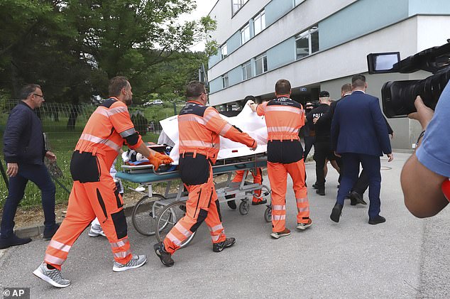 Rescuers carry Slovak Prime Minister Robert Fico, who was shot and wounded, to a hospital in the central Slovak town of Banska Bystrica. He appears in the photo covered by a white sheet.