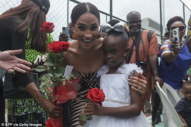 Meghan smiles as she receives flowers during a sitting volleyball match in Abuja last Saturday.