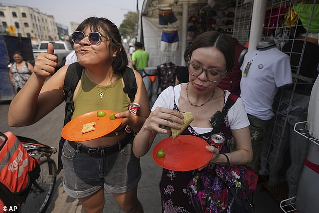 A customer gives a thumbs up while eating a taco straight from Rivera Martínez's grill. The taco stand is the first to receive a Michelin star from the French gastronomic guide.