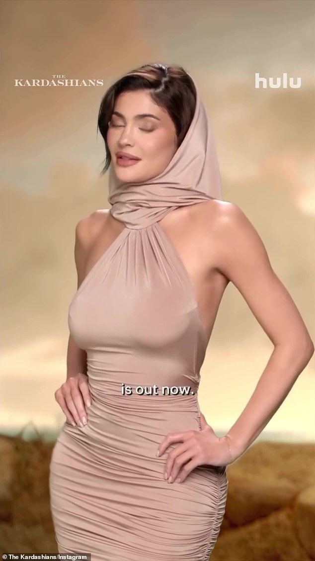 Kylie's sand-toned dress ticks all the 'dune-core' style boxes with its flattering ruching, halter neckline and attached hood.