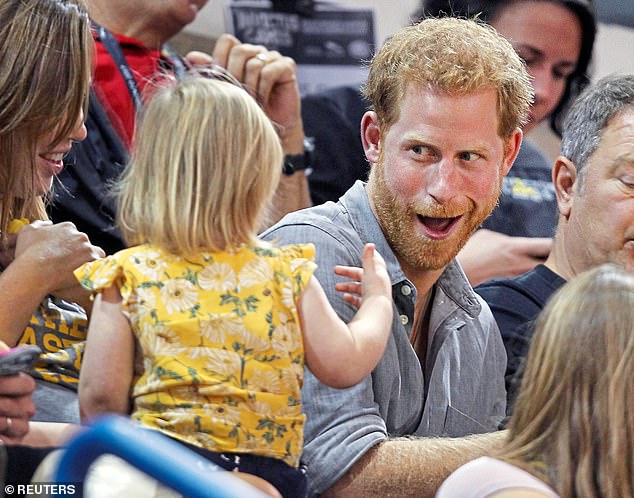 Prince Harry shares popcorn with a child while attending the sitting volleyball competition at the 2017 Invictus Games in Toronto.