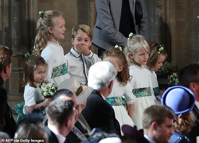 Prince George is caught gossiping with his cousin Savannah Phillips (left) at the wedding of Princess Eugenie and Jack Brooksbank in 2018.