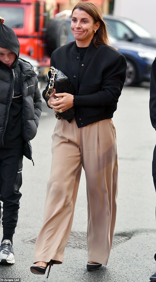 She also wore baggy tan pants with an elastic band and paired them with sleek black heels.