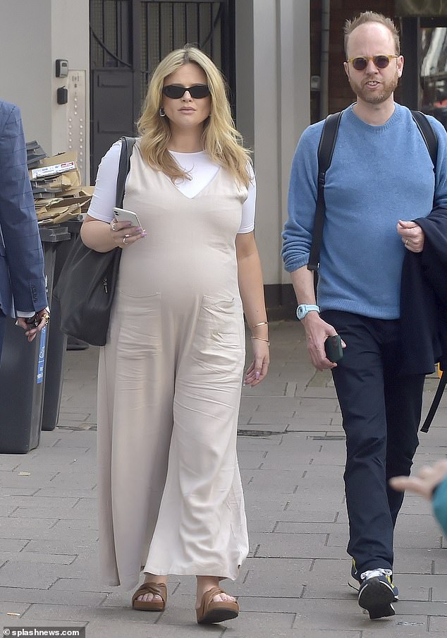 Atack, who is expecting her first child with boyfriend Alistair Garner, wore a seasonal linen dungarees while out and about with a member of her management, Max, in London.