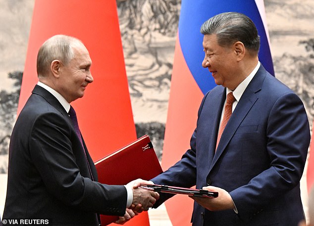 Russian President Vladimir Putin and Chinese President Xi Jinping exchange bilateral documents during a meeting in Beijing, China, on May 16, 2024.