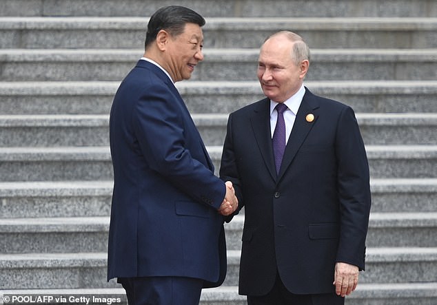 Russian President Vladimir Putin and Chinese President Xi Jinping attend an official welcoming ceremony in front of the Great Hall of the People in Tiananmen Square in Beijing today.