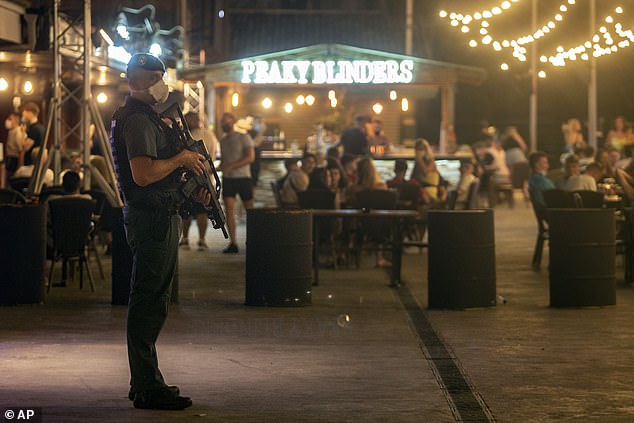 Speaking in court today, the terrified woman recalled how the relative heard her scream for help before being rescued by local police officers. In the photo: A police officer is seen standing guard near a bar in Magaluf (file photo)