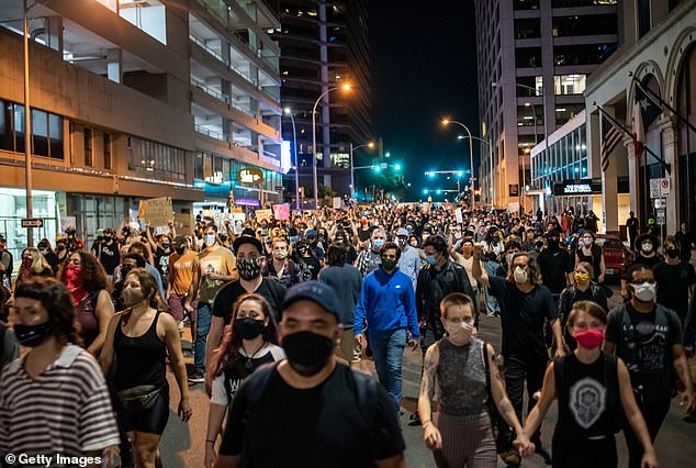 Activists are photographed on July 26, 2020, holding a vigil for Foster, the day after his murder.