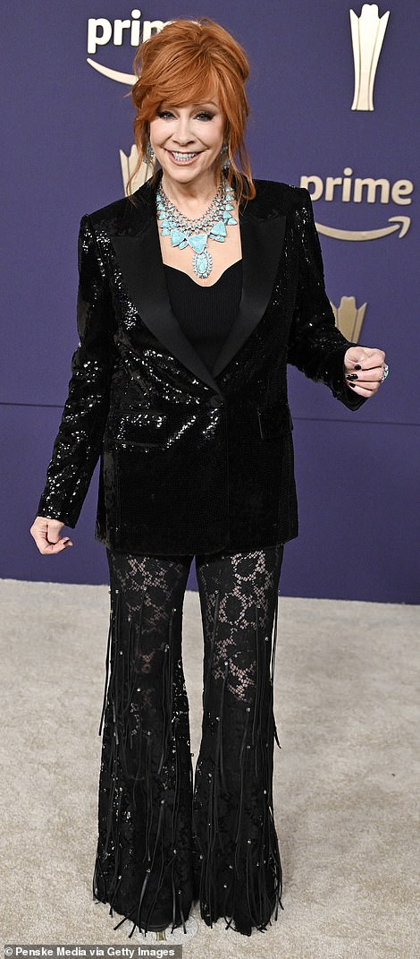 The country music legend, 69, dazzled in a black sequin blazer paired with a low-cut top and sheer fringe pants.