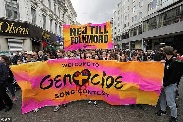 Protesters hold a banner that says 