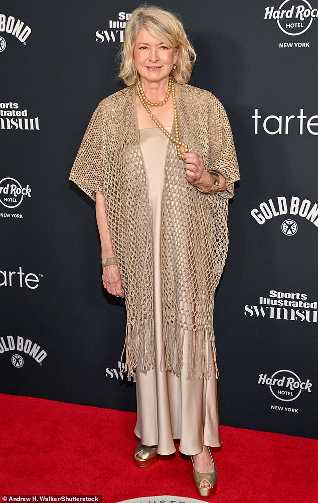 She donned an ankle-length satin dress, underneath a matching champagne-colored mesh woven shawl with a fringed hem.